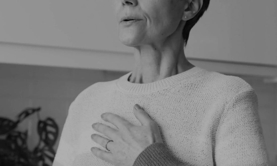 Person with hand on chest in a grounding gesture, representing a burnout self-assessment and checking in with how you feel