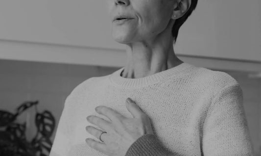 Person with hand on chest in a grounding gesture, representing a burnout self-assessment and checking in with how you feel