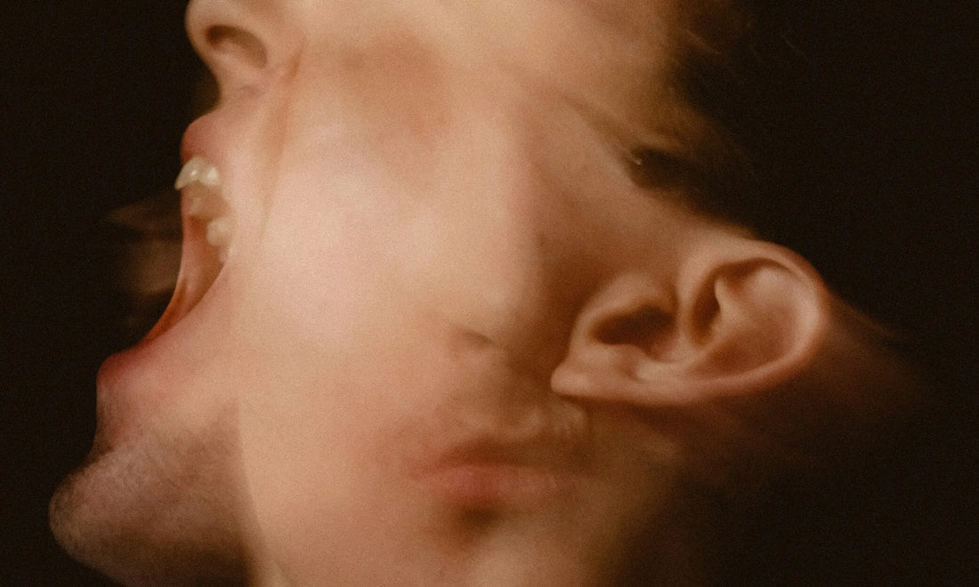 Close-up of a person's face with eyes closed in exhaustion, illustrating the effects of cortisol and burnout on the body